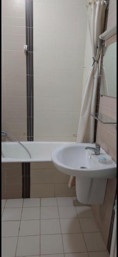 a bathroom with a sink and a bath tub at Appartement superbe à Hammamet in Nabeul