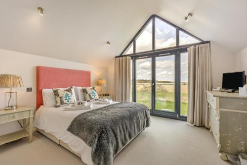a bedroom with a bed and a large window at 3 Bed in Dunwich oc-slh in Dunwich