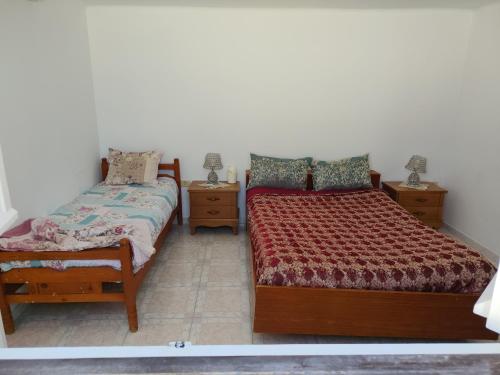 a bedroom with two beds and two night stands at Studio ANDALOUS in Mahdia
