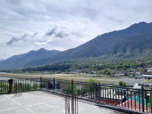 a balcony with a view of a town and mountains at Malti Guest House in Kullu Manali