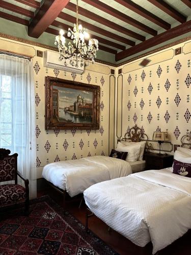a bedroom with two beds and a chandelier at Villa Amore Tuscany in Capannori