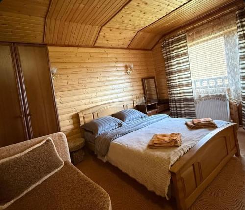 a bedroom with two beds in a wooden room at котедж Квітуча Гора in Yablunytsya