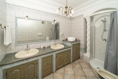 a bathroom with two sinks and a mirror and a tub at Villa Palumbo in Positano