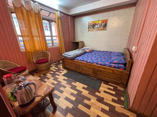 a small bedroom with a bed and a table at Shivaay Inn in Lava