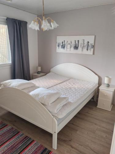 a white bed in a room with a window at Pikkurinki 28 As 2, 62300 Härmä Kauhava in Alahärmä