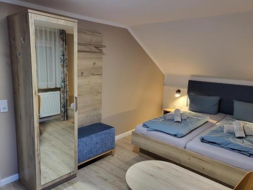 a small room with two beds and a mirror at Gästehaus am Bahnhof Norddeich in Norddeich