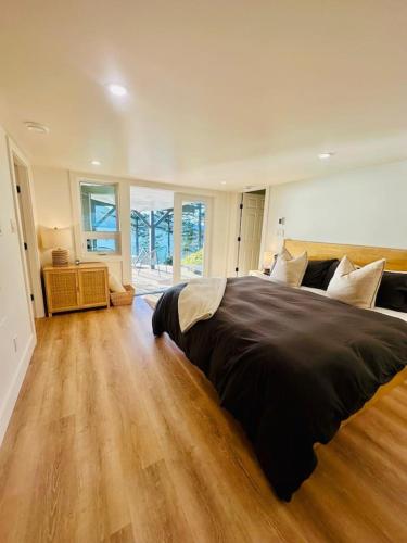 a large bedroom with a large bed and wooden floors at Gorgeous Ocean and Mountain View King Suite in Bowen Island