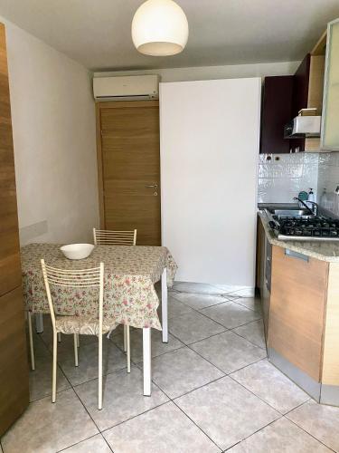 a kitchen with a table and chairs and a kitchen with a stove at MiniAppartamento Laura - Piano terra in Chioggia