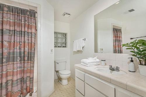 a white bathroom with a toilet and a sink at Sequoia Riverfront House With Beach Access in Three Rivers