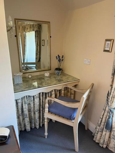 a bathroom with a vanity with a mirror and a chair at The Old Stone Barn in Warrington