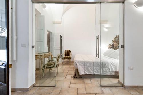 a bedroom with a bed and a table and chairs at Antoglietta Suites Lecce Selection in Lecce