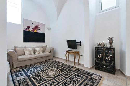 a living room with a couch and a tv at Antoglietta Suites Lecce Selection in Lecce