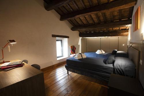 a bedroom with a bed and a desk with a lamp at Casolare Brindavan Dimora Artemisia in Vaccareccia