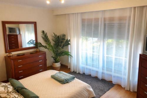 a bedroom with a bed and a dresser and a window at Oporto Beach Apartment in Vila Nova de Gaia