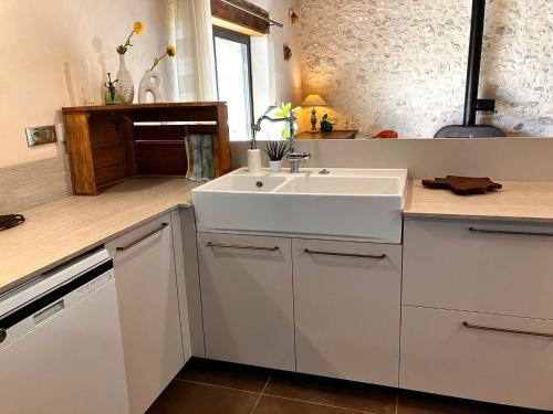 a kitchen with a white sink and a counter at Périgourdine avec spa et vue in Pomport