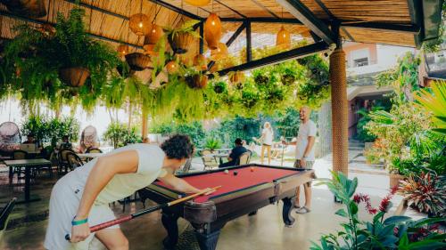 a woman playing a game of pool in a restaurant at Viajero Cali Hostel & Salsa School in Cali