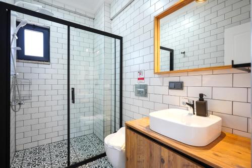 a bathroom with a sink and a glass shower at Meva Luxury Apartments in Muğla