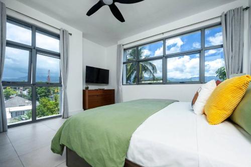 a bedroom with a bed and large windows at Stylish Condo with Rooftop Pool and Gym in Kingston