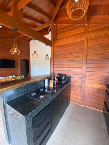a kitchen with wooden walls and a counter top at Cerrado da Canastra Chalé com Banheira in São Roque de Minas