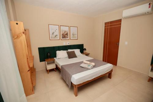 a bedroom with a bed with a green headboard at Apartamento 2 Vargem Grande RJ in Rio de Janeiro