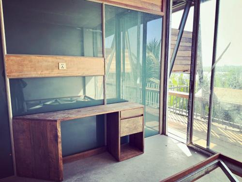 a room with a wooden desk with a large window at Chum Home - 02 in Danang