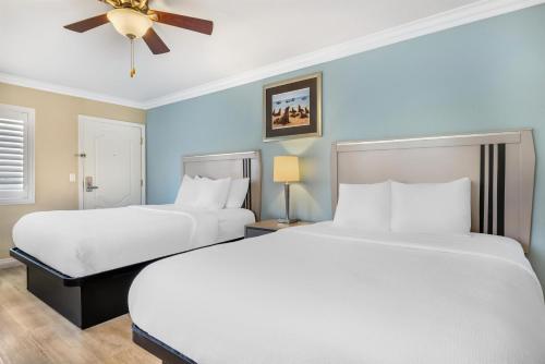 two beds in a hotel room with a ceiling fan at Best Western Tradewinds in Morro Bay