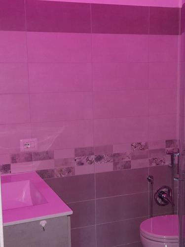 a pink bathroom with a sink and a toilet at Sognando nel borgo in Rocca Imperiale