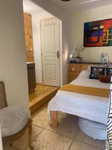 a bedroom with a bed and a chair in it at DEPENDANCE PRIVEE - HALTE ROUTE in Le Thor