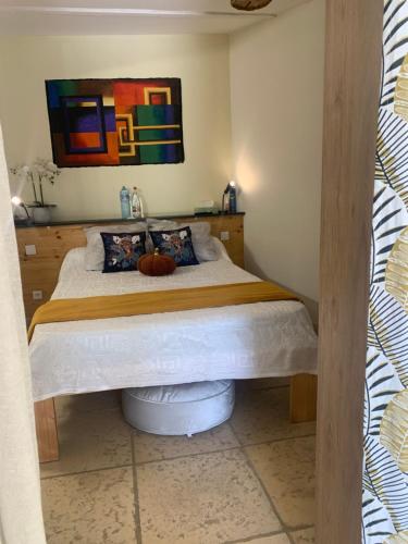 a bedroom with a bed with a painting on the wall at DEPENDANCE PRIVEE - HALTE ROUTE in Le Thor