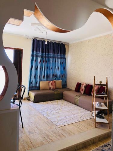 a living room with a couch and a blue curtain at Dar Mariem Douz in Douz