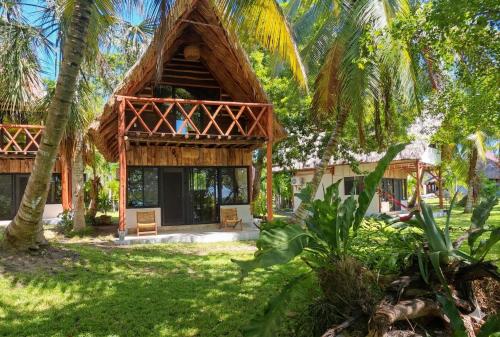 a resort with a thatched building with palm trees at Xanthus Hotel in Huay Pix