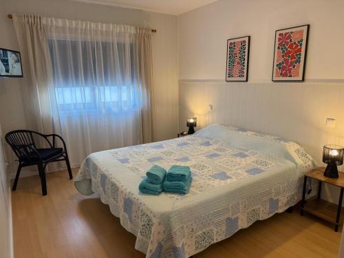a bedroom with a bed with two green towels on it at Trajadinha in Vila Praia de Âncora