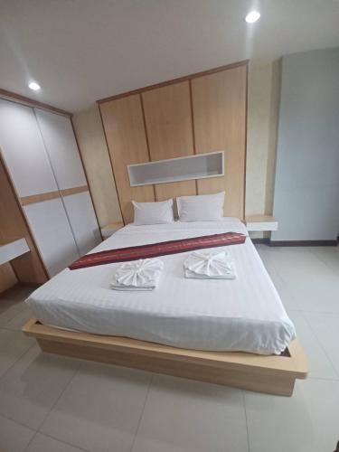 a bedroom with a large bed with white sheets at Valhalla Pattaya Hotel in Jomtien Beach