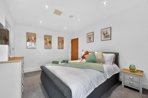a bedroom with a large bed and some pictures on the wall at The Oak Nest in Otford