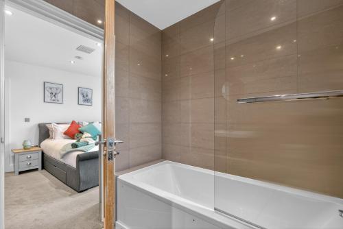 a bathroom with a tub and a bed in a room at The Oak Nest in Otford