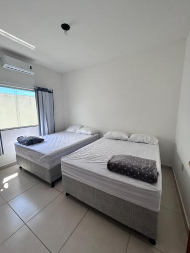 two twin beds in a room with a window at Casa Prado in Prado