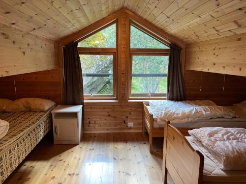 a room with two beds in a log cabin at Melkevoll Bretun Camping in Briksdalsbre
