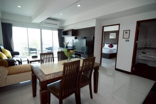 a kitchen and living room with a table and a couch at Valhalla Pattaya Hotel in Jomtien Beach