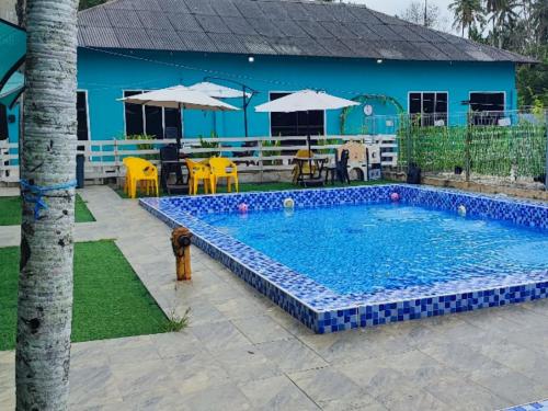a pool with a fire hydrant in front of a house at Green Forest Resort in Setiu