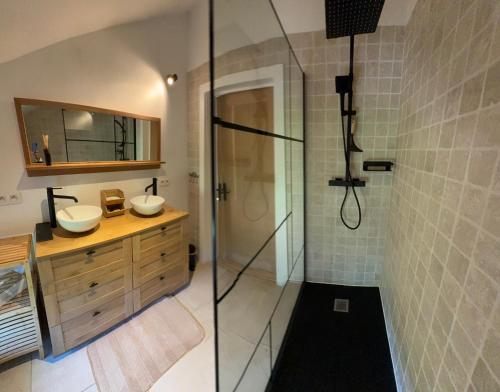 a bathroom with two sinks and a shower at La Petite Maison Blanche in Wanze