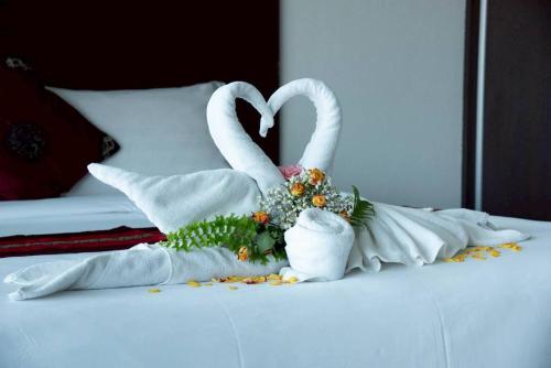 two swans made out of towels on a bed at Valhalla Pattaya Hotel in Jomtien Beach