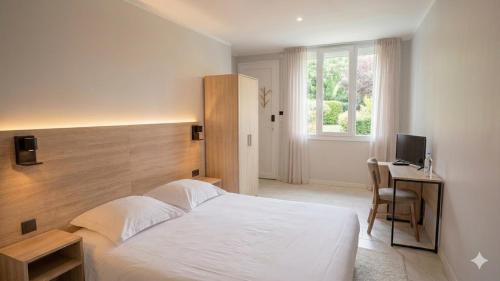 a bedroom with a bed and a desk and a television at VTF Village de vacances Le Domaine d'Agde in Agde