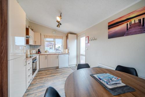 a kitchen and dining room with a table and chairs at 2 Bed Cabin - Sleeps 4 - Pets - 5 min to Beach in Bridlington