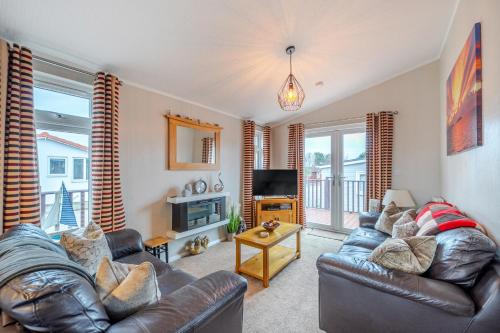 a living room with two leather couches and a television at 2 Bed Cabin - Sleeps 4 - Pets - 5 min to Beach in Bridlington