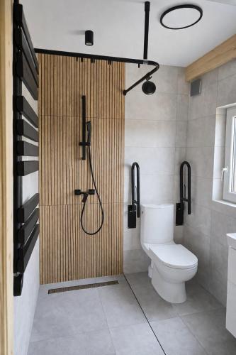 a bathroom with a shower stall and a toilet at Noclegi Przy Karczmie in Makowiec