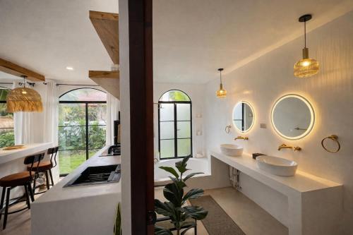 a bathroom with two sinks and two mirrors at Villa Adela Siargao in General Luna