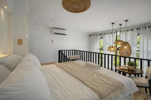 a bedroom with a large bed and a balcony at Villa Adela Siargao in General Luna