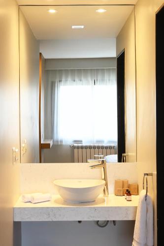 a bathroom with a sink and a large mirror at Hotel Nevada in San Carlos de Bariloche
