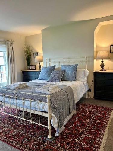 a bedroom with a bed with blue pillows on it at Barley House, Sea and Beach Facing Accommodation in Southwold