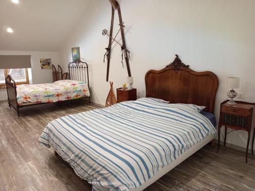 a bedroom with a bed with a striped comforter at studio3 spacieux 1à4 pers in Marboz